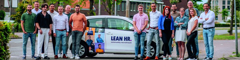 De mensen van LEAN HR, dé HR-dienstverlener van Limburg, poseren voor één van de bedrijfsauto's.